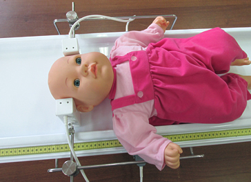 Расположение головы ребёнка между терминалами излучателя "ОГОЛОВЬЕ" при проведении процедуры лечения перинатальных поражений ЦНС, включая гипертензионно-гидроцефальный синдром.